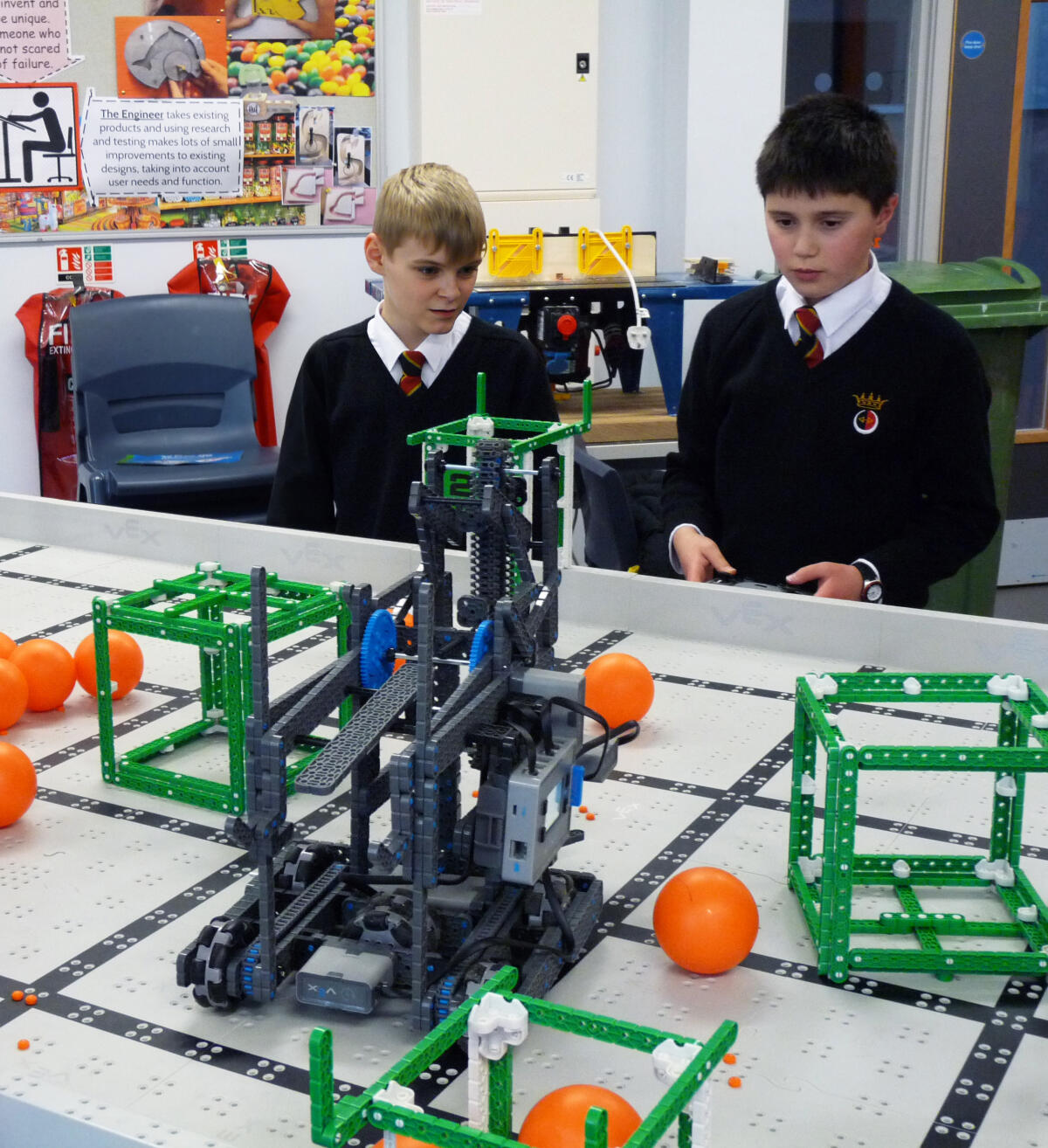 Some heats in the Vex IQ Challenge involve driving the robot to pick up objects and place them in point-scoring areas.